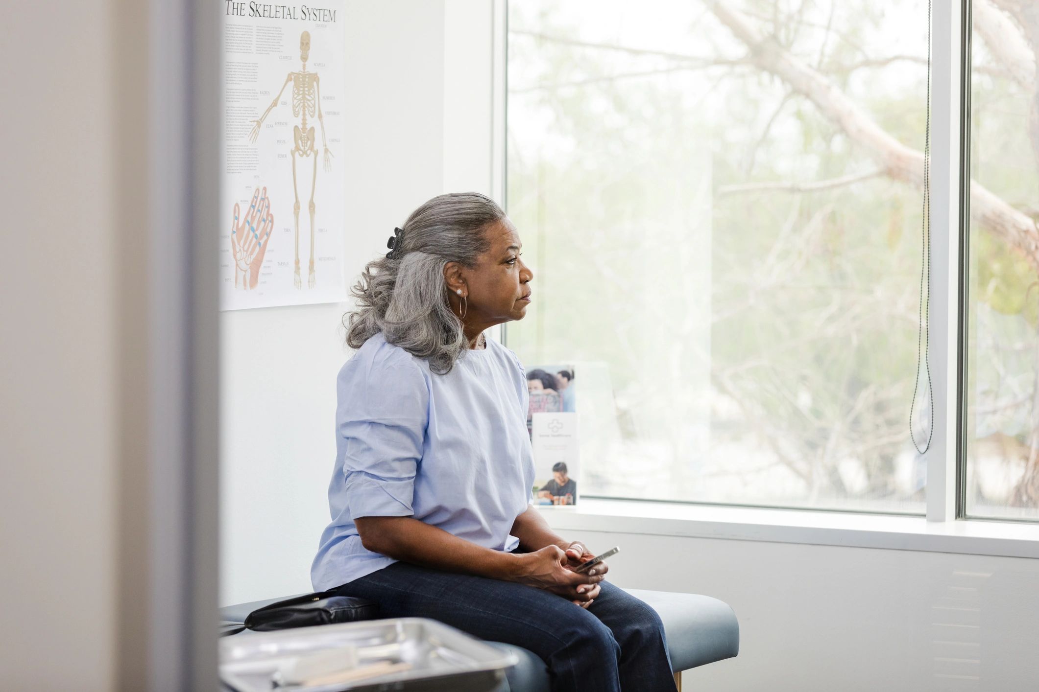 Patient waiting in exam room with phone