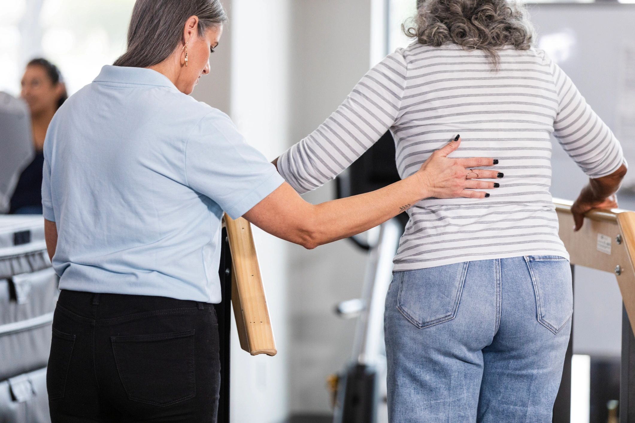 Physical therapist supporting a patient during mobility training