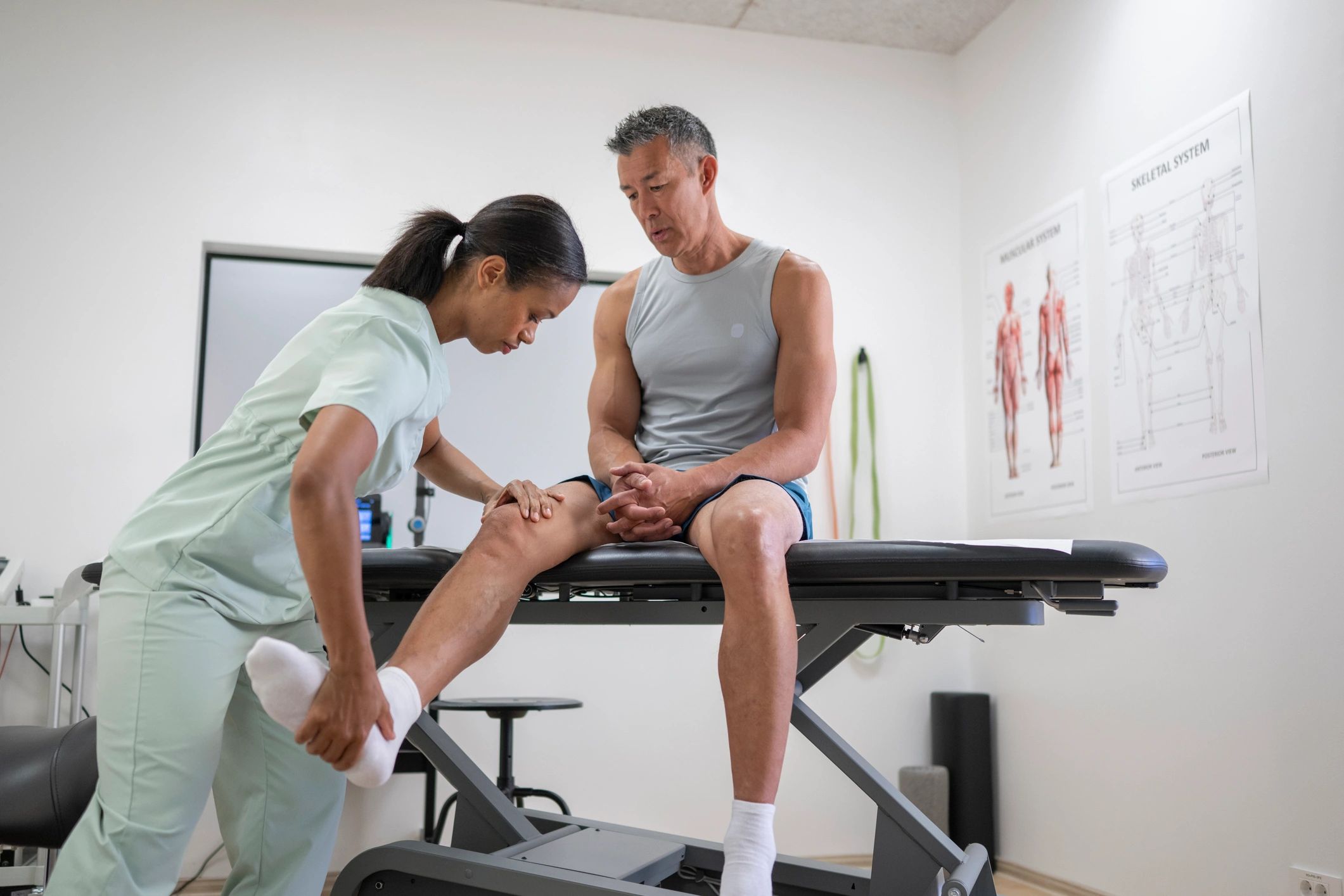 Clinician providing knee injury treatment in a clinic