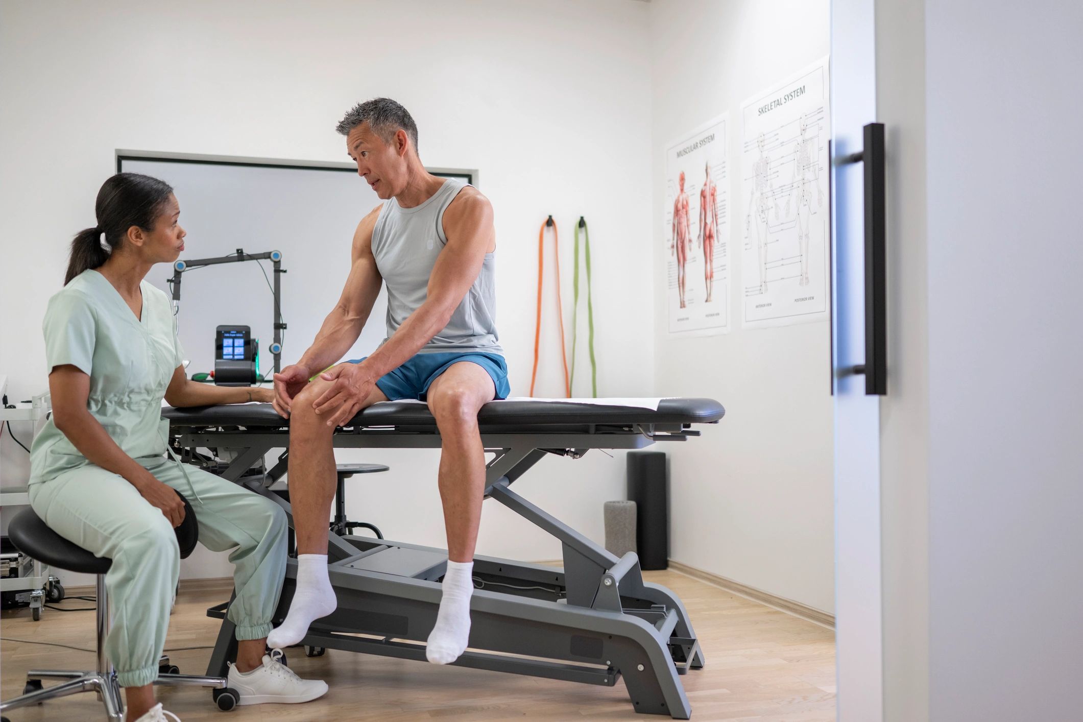 Clinician evaluating a patient's knee in a clinic